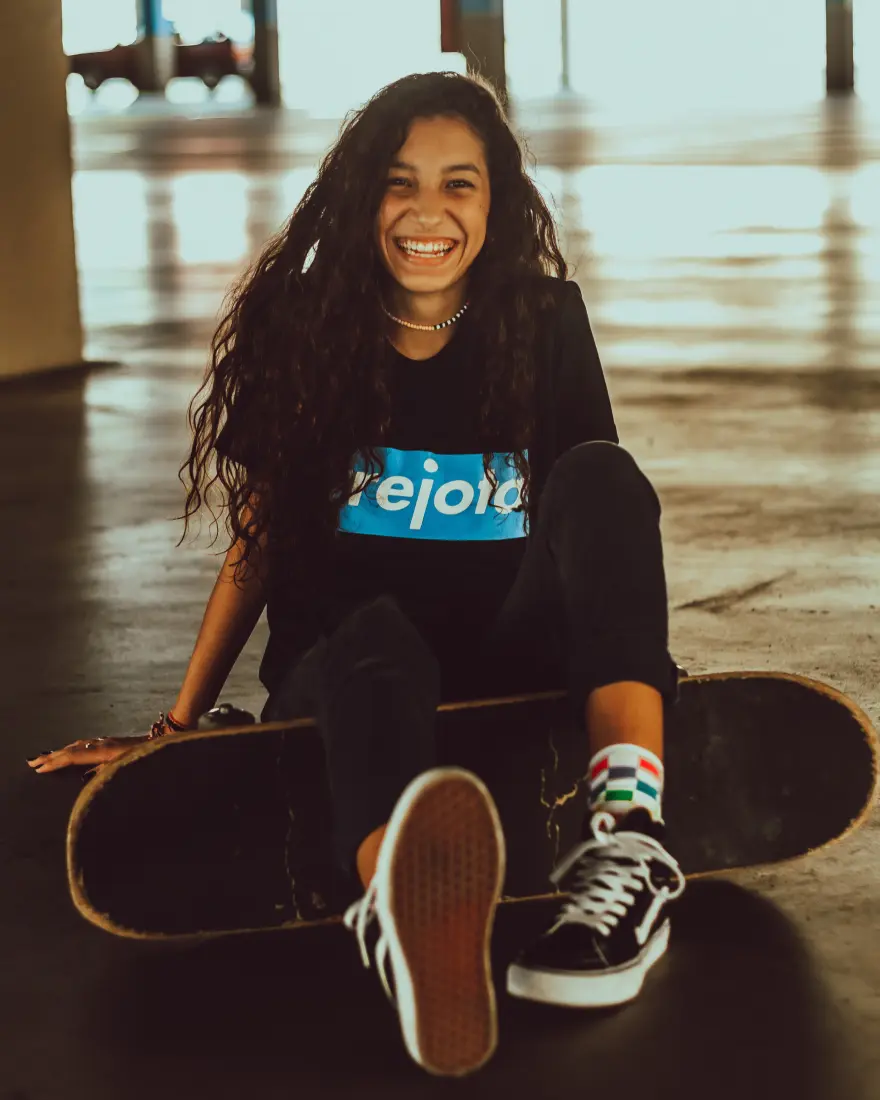 Teenager sitting on the floor with a skateboard