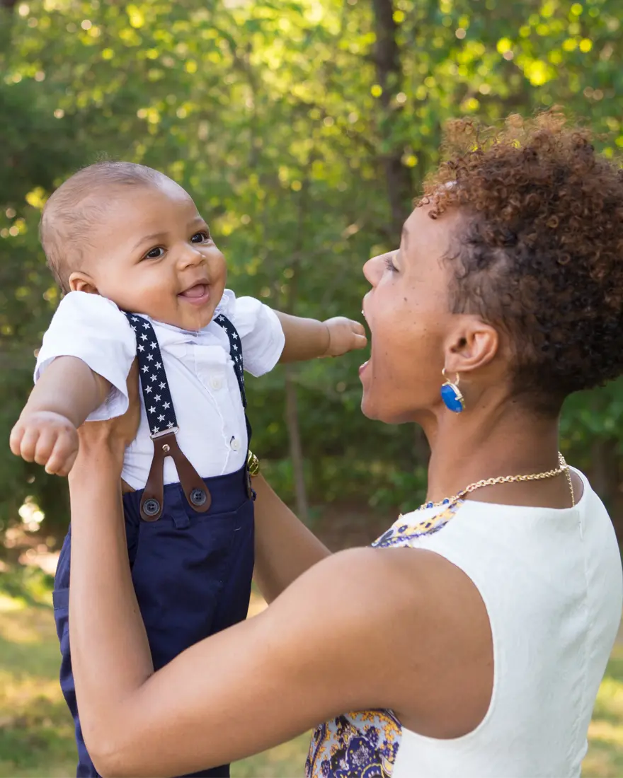 Adult holding baby outdoors