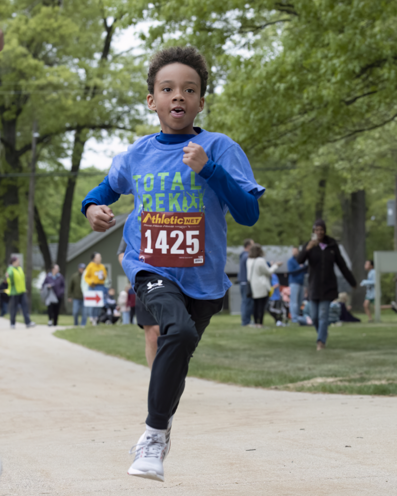 Young boy running in TTQ shirt during 5k