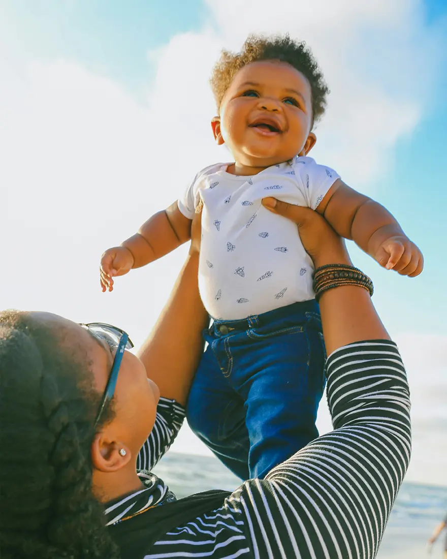 Mother holding baby on the beach