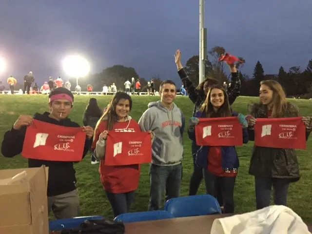 Students holding red towels at a sporting event