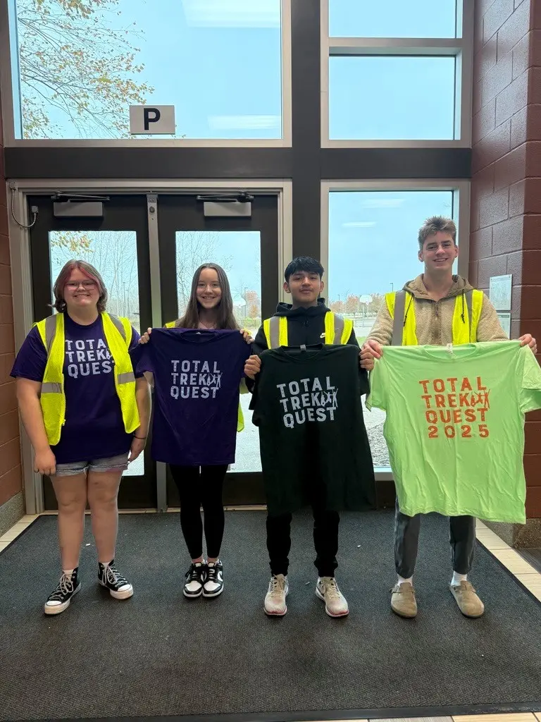 Students holding Total Trek Quest t-shirts