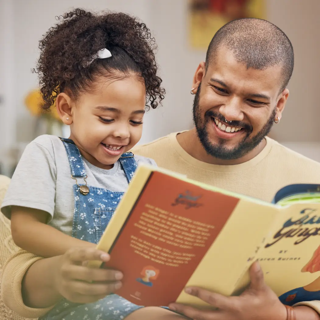 Father and daughter reading a children's book