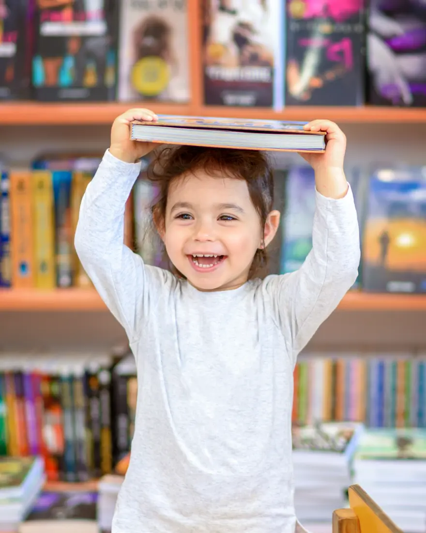 Girl holding book above head